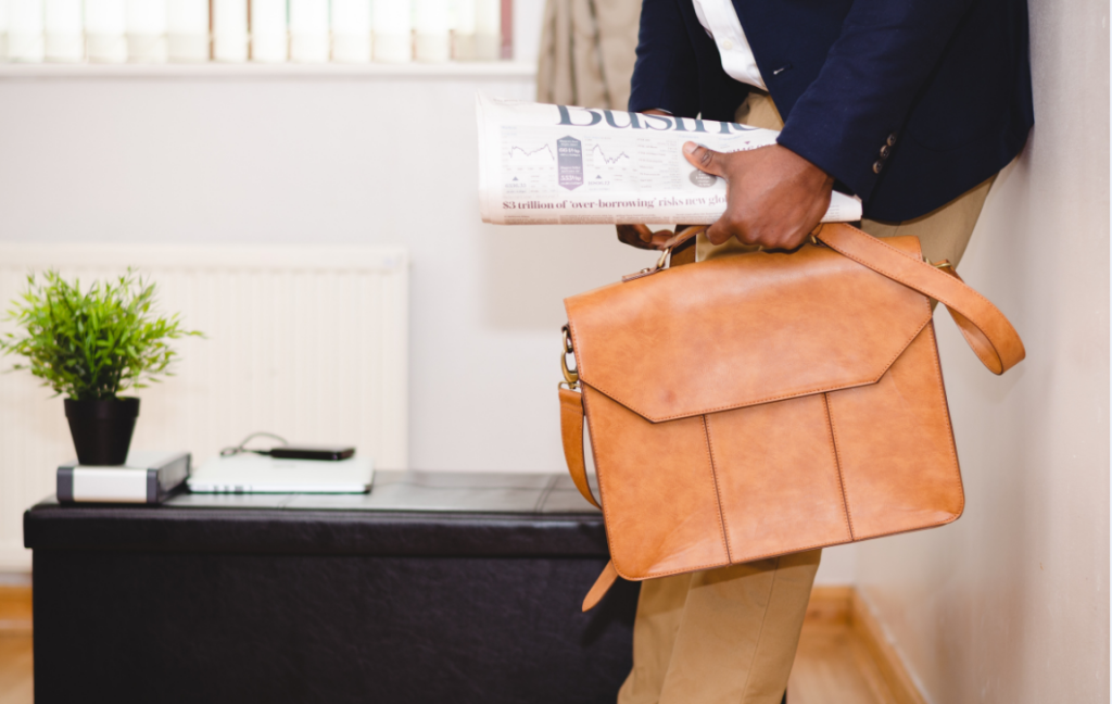 Homme d'affaires avec cartable en cuir et journal économique